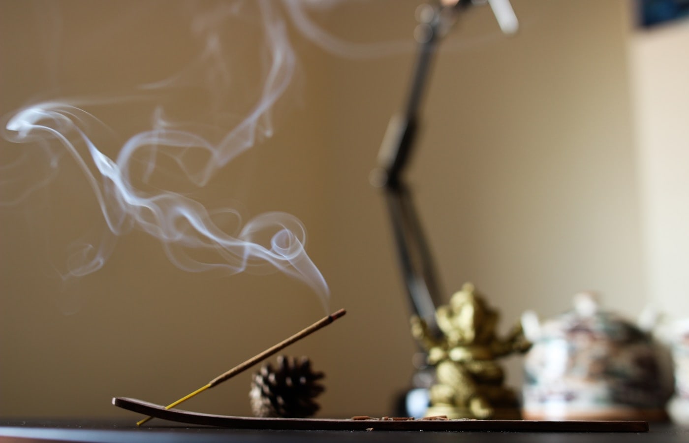 Warm incense smoke rising from a burner for bakhoor rituals