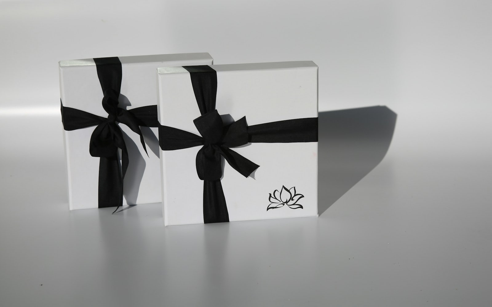 Elegant black and white fragrance gift boxes with ribbon